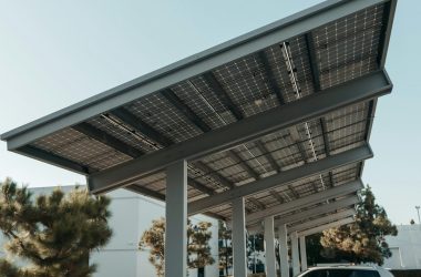 Cars parked under solar panel structures in a modern parking lot utilizing renewable energy.